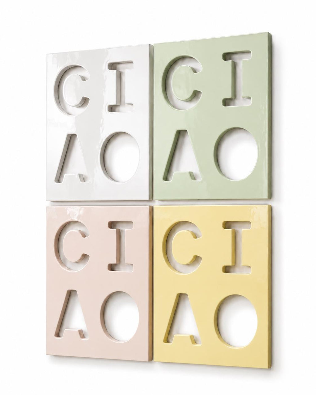 Four rectangular wall tiles arranged in a square grid. Each tile features cut-out letters spelling CICI and CIAO. The tiles are colored white, light green, pale pink, and soft yellow, all with a smooth, glossy, reflective finish.