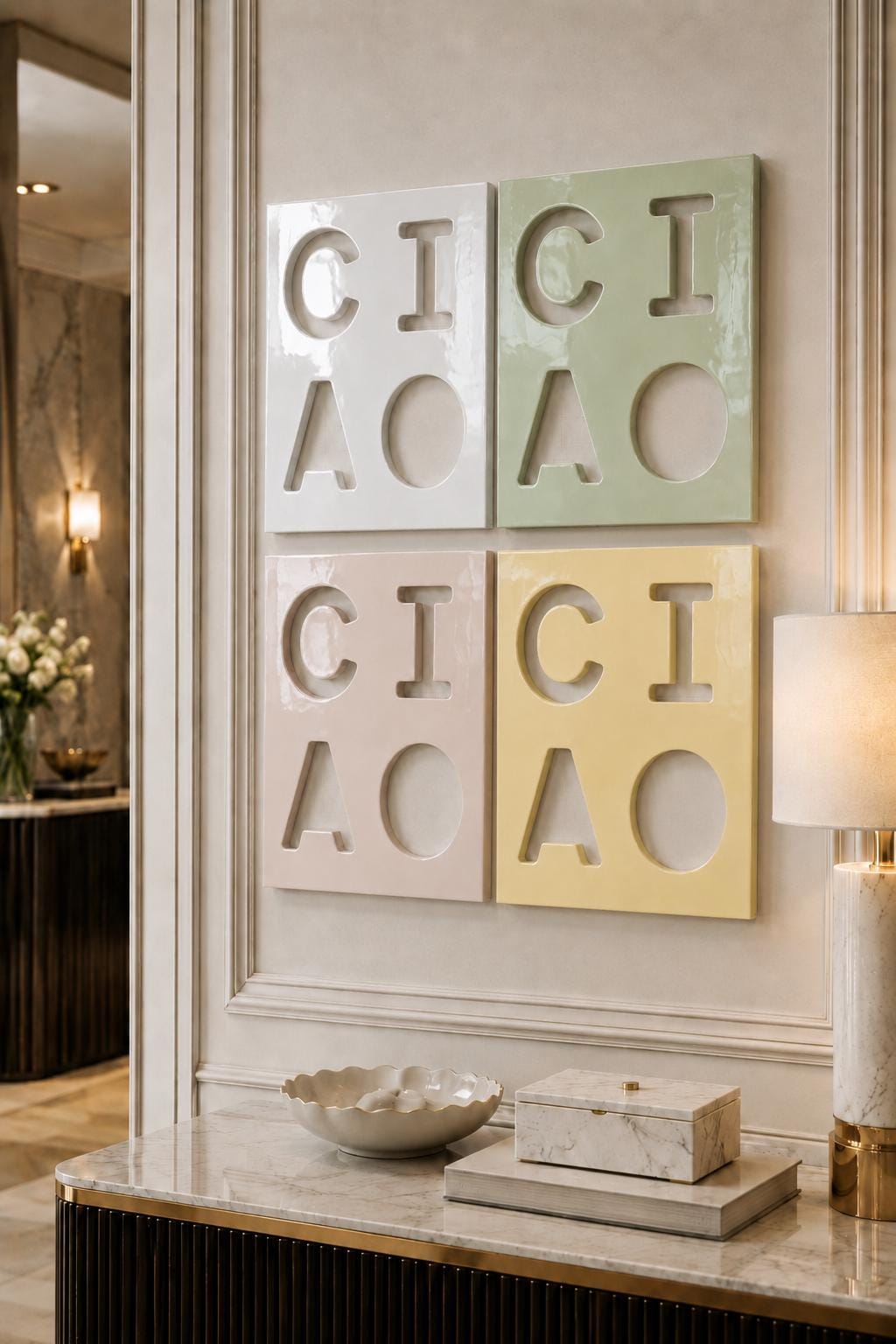 Four square wall art panels arranged in a grid, each featuring cut-out letters spelling CICI AOAO. The panels are finished in glossy white, sage green, dusty pink, and pale yellow, creating a colorful geometric display on the wall.