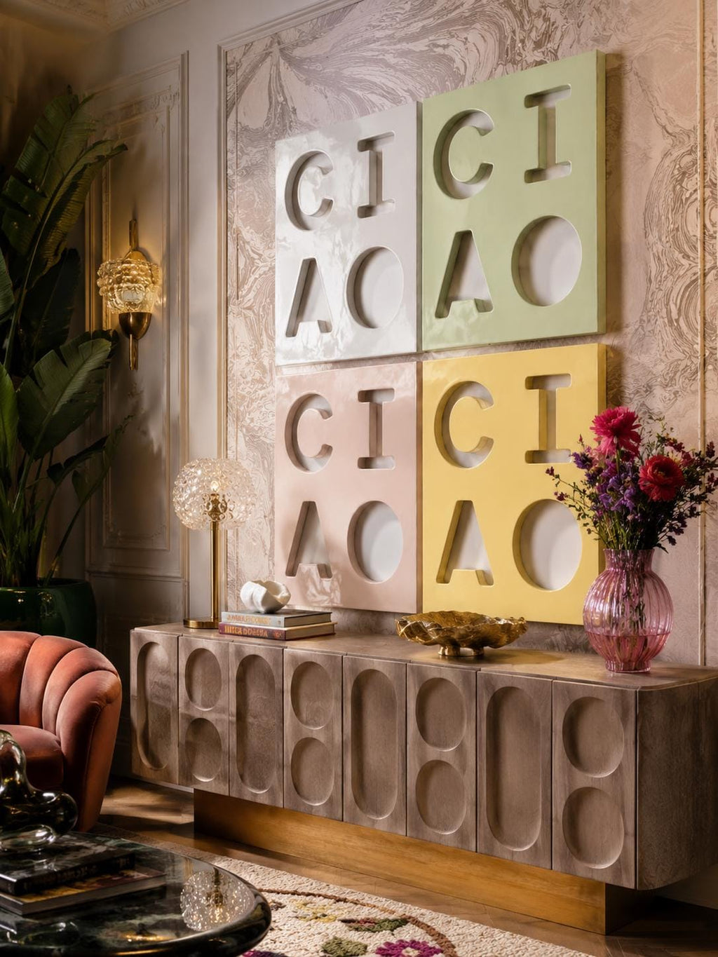 A rectangular wooden sideboard with a textured, repeating oval pattern on its cabinet doors, topped with a four-panel wall art piece featuring the letters CICI ACAO in light green, white, pale pink, and yellow square frames.