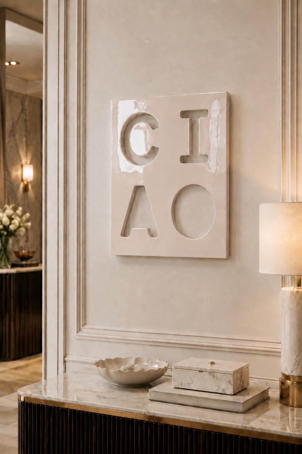 A square, glossy, off-white ceramic wall plaque featuring the debossed letters C, I, A, and O arranged in a two-by-two grid. The surface has a smooth, reflective finish with subtle indentations forming the characters.