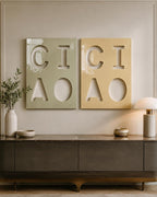 Two rectangular wall art panels featuring cut-out letters. The left panel is sage green with the letters C, I, A, and O. The right panel is mustard yellow with the same letters C, I, A, and O. Both panels have a glossy, smooth finish.