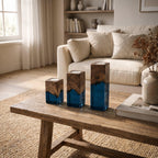 Three square candle holders of varying heights, each crafted from a combination of natural brown wood at the top and translucent deep blue resin at the base, featuring a circular opening at the top for a tea light candle.