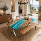 A rectangular dining table featuring a natural wood slab with a central river design made of bright turquoise resin that mimics ocean waves with white foam accents. The table is supported by a silver metal X-shaped base.