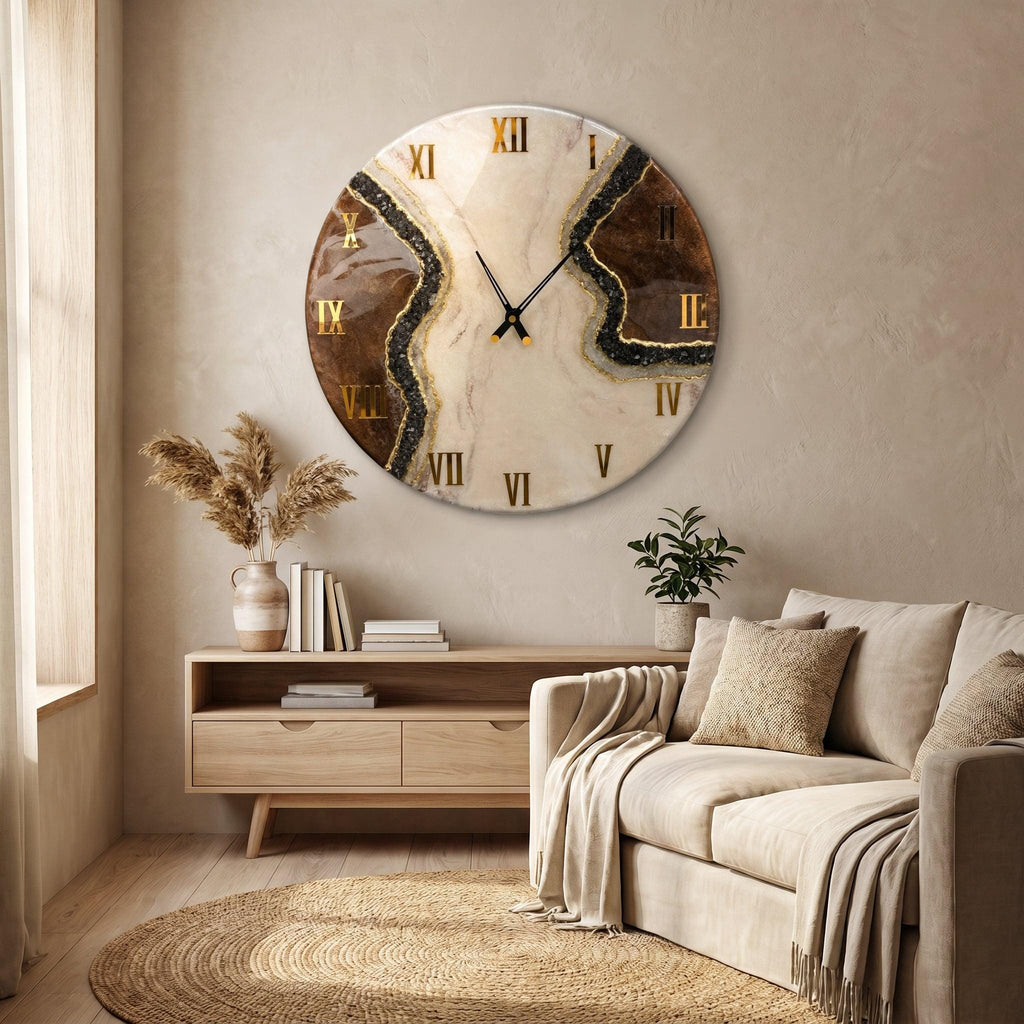 A circular wall clock featuring a marbled cream and brown resin surface with gold-colored Roman numerals. The design includes a textured black glittery vein running diagonally across the face, complemented by thin black metal clock hands.
