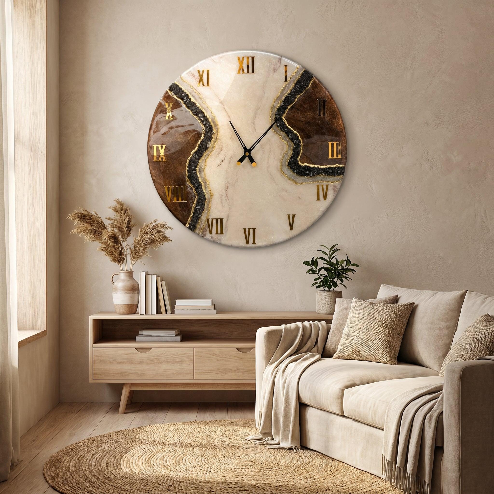 A circular wall clock featuring a marbled cream and brown resin surface with gold-colored Roman numerals. The design includes a textured black glittery vein running diagonally across the face, complemented by thin black metal clock hands.