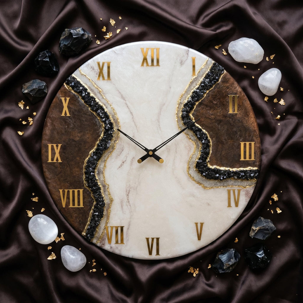 A round wall clock featuring a white and brown marbled face with a central jagged fissure filled with black crystals and gold accents. The clock has gold Roman numerals and thin black hands, surrounded by scattered black and white stones.
