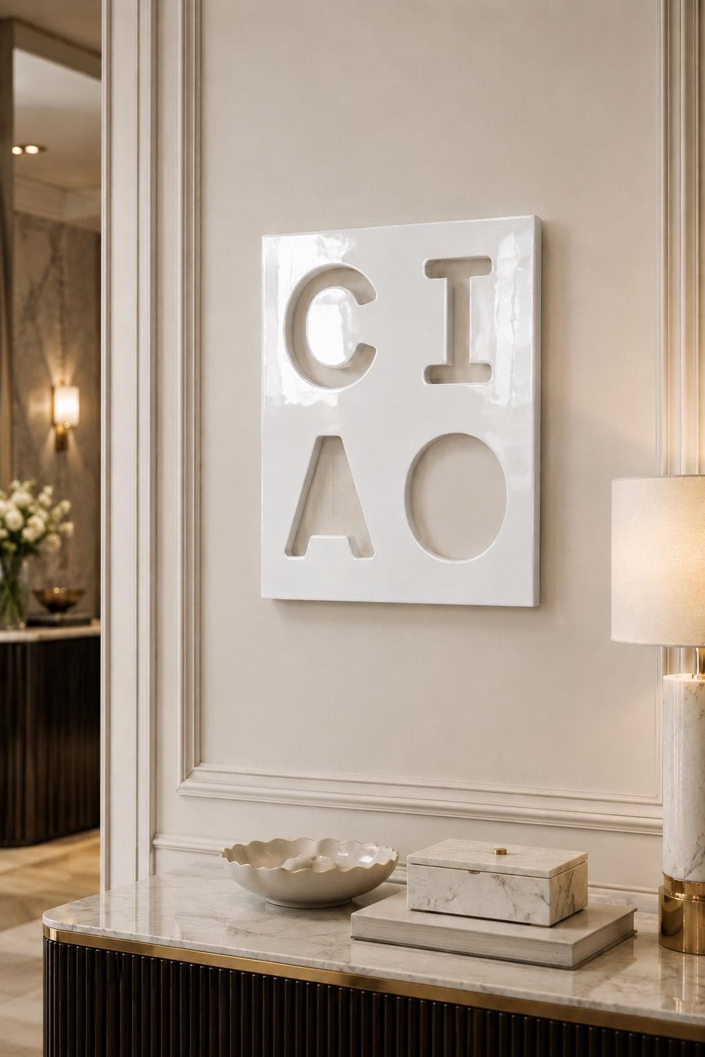 A square white wall plaque featuring the word CIAO embossed in a block-letter style. The letters C, I, A, and O are arranged in a two-by-two grid pattern on the glossy, smooth surface of the white ceramic or resin decorative piece.