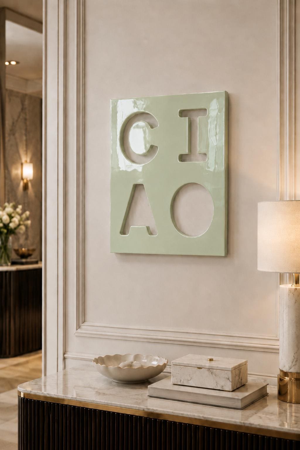 A square, light green wall plaque featuring the cutout letters C, I, A, and O arranged in a two-by-two grid. The surface of the plaque has a glossy, reflective finish, and the letters are formed by negative space against the wall.
