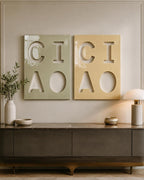 Two rectangular wall art panels featuring cut-out letters. The left panel is sage green with the letters C, I, A, and O. The right panel is mustard yellow with the same letters C, I, A, and O. Both panels have a glossy, smooth finish.