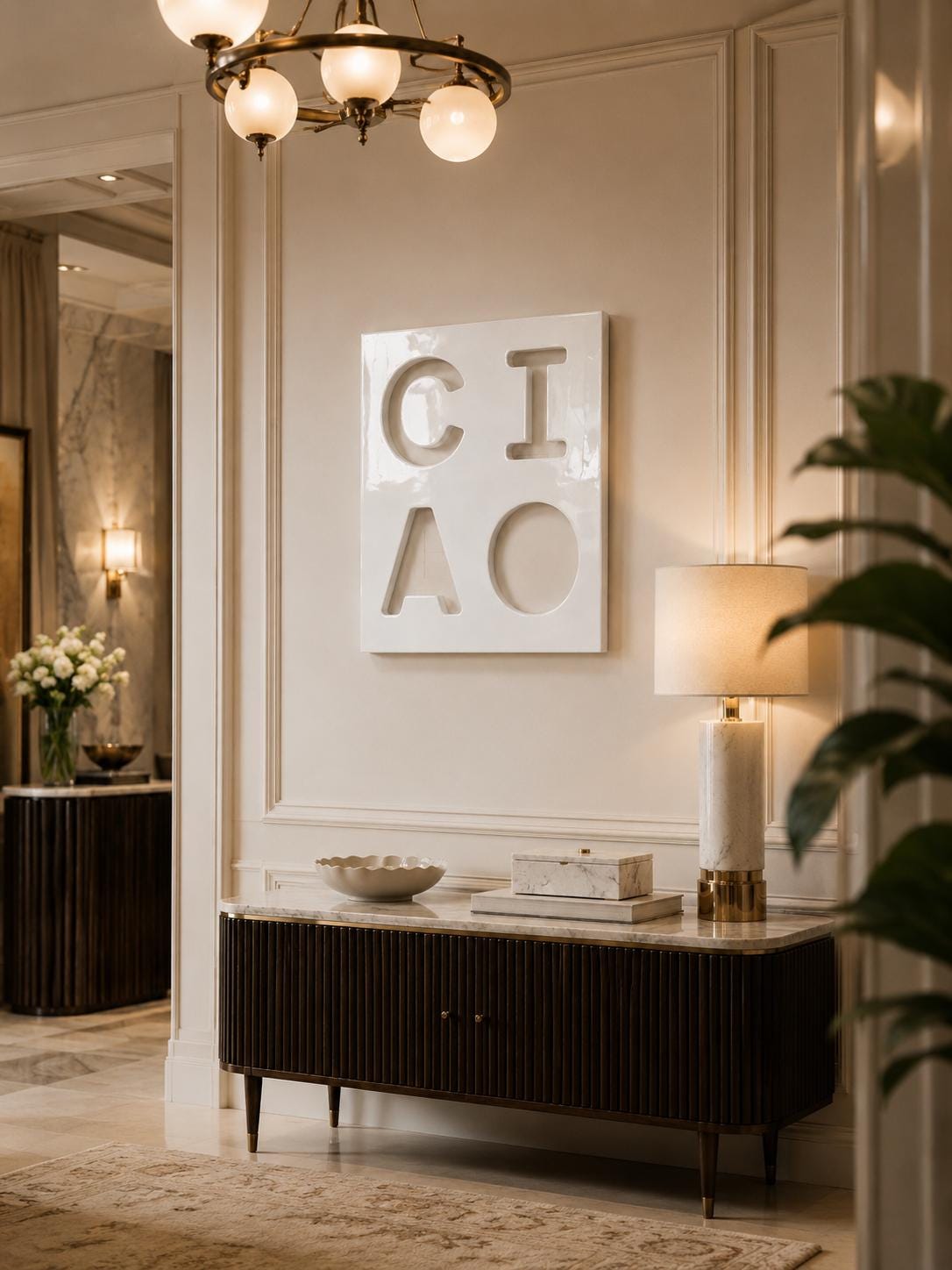 A white square wall art piece featuring the cutout letters C, I, A, and O arranged in a two-by-two grid. The artwork is mounted on a beige wall above a dark brown fluted sideboard with a marble top, a marble lamp, and a bowl.