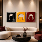 Three square wall art panels featuring glossy cutouts of stylized hair silhouettes. The left panel is black, the center panel is yellow, and the right panel is deep red. Each piece displays a distinct hairstyle shape against a solid background.