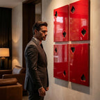Four glossy red rectangular wall panels arranged in a square grid, each featuring a cutout shape representing a playing card suit, including clubs, spades, diamonds, and hearts, mounted on a light-colored interior wall surface.