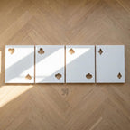 Four rectangular white panels arranged in a row, each featuring two cut-out shapes representing playing card suits. The first panel shows a heart and a spade, the second a club and a club, the third a spade and a spade, and the fourth a diamond and a diamond.