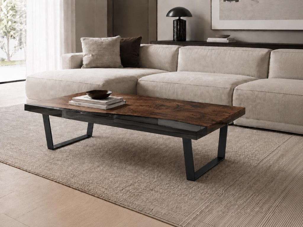 A rectangular coffee table featuring a dark brown wood grain top with a smooth finish and a clear glass inlay section. The table is supported by four black metal legs arranged in a wide, angled U-shape design, providing a stable base.