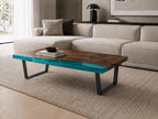 A rectangular coffee table featuring a dark brown wood grain surface with a vibrant, translucent turquoise resin edge. The table is supported by two black metal U-shaped legs, providing a stable base for the wooden and resin tabletop.