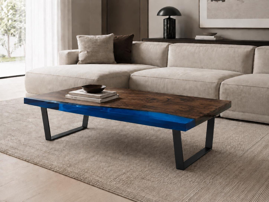 A rectangular coffee table featuring a natural dark brown wood slab surface with a vibrant blue resin inlay along the side, supported by two black metal U-shaped legs. The table surface displays a visible wood grain pattern.