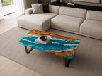 A rectangular coffee table featuring a natural wood slab with a live edge and a central resin inlay designed to resemble ocean waves with shades of turquoise, blue, and white foam. The table is supported by black metal legs.