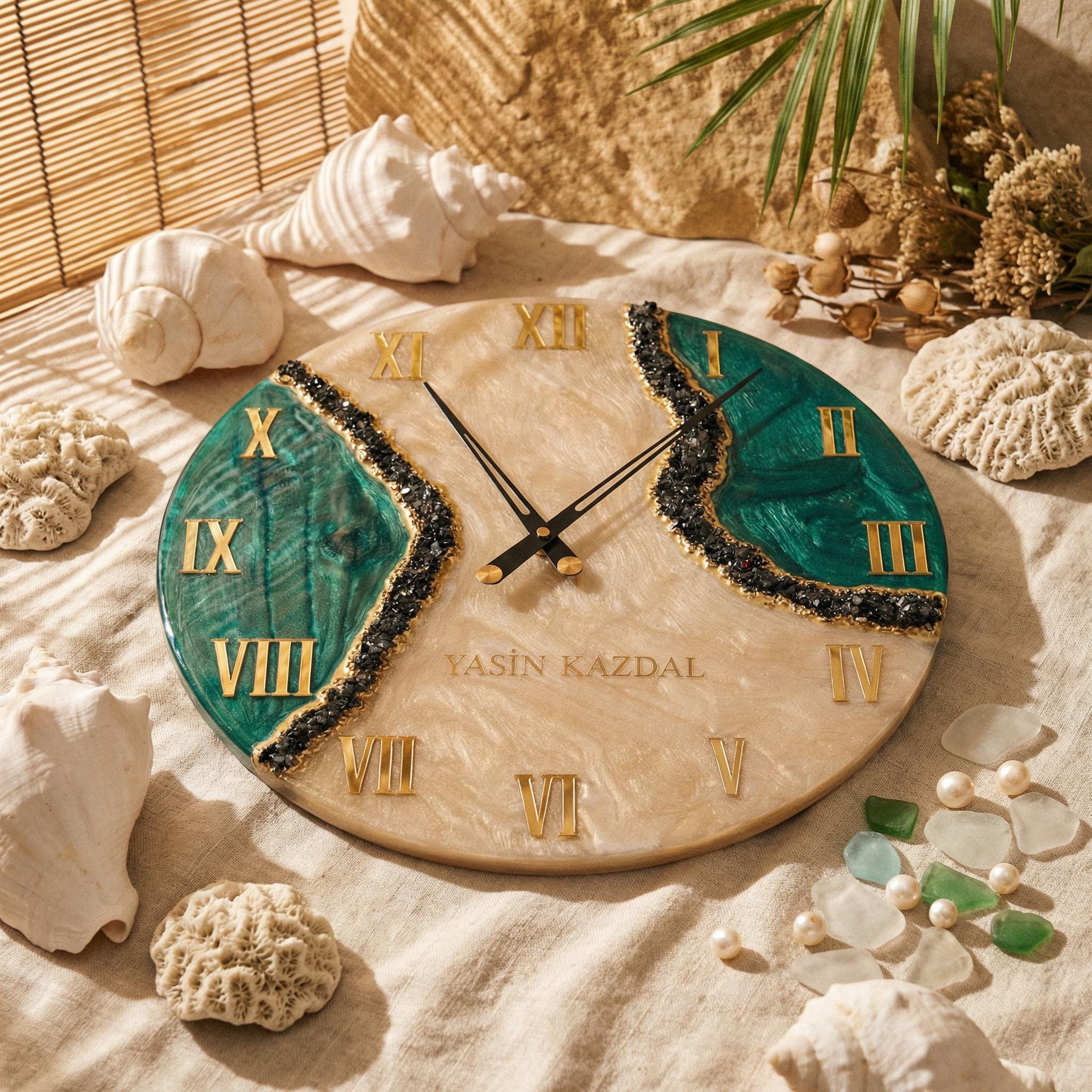 A round wall clock with a beige marbled resin base, featuring two deep green resin sections separated by black crushed stone accents. It has gold Roman numerals, black clock hands, and the text YASIN KAZDAL printed in gold.