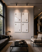 Four rectangular white wall panels arranged in a grid, each featuring cut-out shapes representing playing card suits including clubs, hearts, diamonds, and spades. The glossy panels are mounted on a smooth, neutral-toned wall surface.